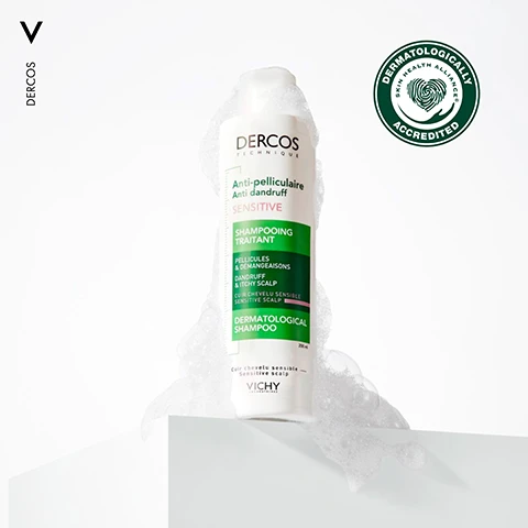 Image 1 - A bottle of Dercos Anti-Dandruff Shampoo, covered in bubbles, is placed on a white surface with a green and white dermatological accreditation seal in the top right corner.
Image 2 - A close-up image of a person with dark, curly hair holding their hair back, accompanied by text that reads REMOVES VISIBLE FLAKES FROM FIRST USE FOR SENSITIVE SCALP.
Image 3 - A young man with curly hair poses with one hand on his head, showcasing tattoos on his arms, with the text UP TO 6 WEEKS ANTI-DANDRUFF PROTECTION* displayed in green at the bottom.
Image 4 - Image shows two sections with textured backgrounds: the left side has the text 1.3% SALICYLIC ACID, and the right side features 1% PIROCTONE OLAMINE, with the caption DERCOS LEAVES SENSITIVE SCALP FEELING SOOTHED & BALANCED at the bottom.
Image 5 - Image shows bubbles against a light background with the text Gentle Formulation + Pleasant Texture + Leaves Hair Feeling Clean & Comforted.