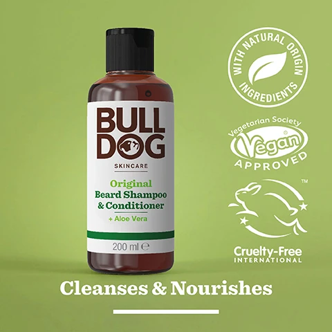 Image 2 - A brown bottle of Bulldog Skincare Original Beard Shampoo and Conditioner with a black cap, featuring text highlighting its natural ingredients, vegan approval, and cruelty-free certification, set against a light green background, with the phrase Cleanses & Nourishes displayed prominently.
Image 3 - A close-up image of a translucent, green gel sitting on a smooth, white surface, featuring the text 92% Natural Origin, Unlock the true potential of natural origin ingredients, and Cleanse & Nourishes.
Image 4 - A person is holding a bottle of beard shampoo labeled Bulldog Skincare for All Beard Types, with some product being dispensed into their other hand.
Image 5 - A bottle of Bulldog Original Beard Shampoo & Conditioner sits on a bathroom countertop with a label indicating it is made from 97% recycled PCR plastic.
Image 6 - Three Bulldog Skincare products for beards are displayed on a shelf, including a bottle of beard oil, a bottle of beard shampoo and conditioner, and a jar of beard balm, with the text Tame Your Beard at the bottom.